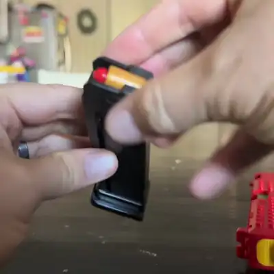 A loaded shell is pushed into the magazine