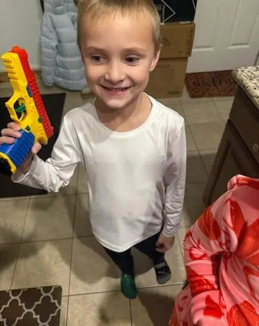 Customer photo from Ryan Q.: a smiling boy holds up his Brick Blaster